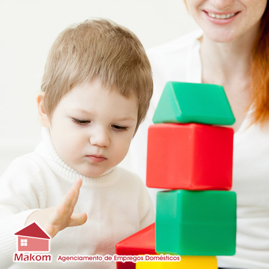 Foto de babá com bebê no colo e limpando o quarto com aspirador - Profissionais - Babá Arrumadeira - Agência Makom