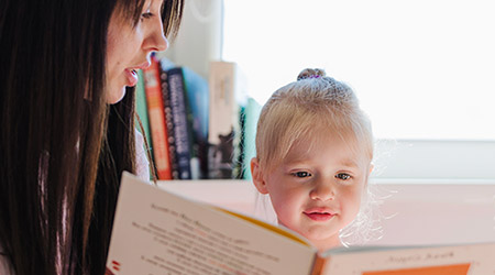 Foto de babá lendo livro para uma criança - Profissionais - Babás - Agência Makom